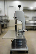Full front view of a commercial frozen meat and bone saw machine
Side angle of a stainless steel cutting saw in a commercial kitchen
Bone saw machine in use, cutting frozen meat
Operator slicing frozen beef bones with an electric meat saw
Commercial food processing bone cutting equipment in operation
Close-up of adjustable blade on automatic bone saw