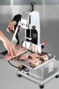 Full front view of a commercial frozen meat and bone saw machine
Side angle of a stainless steel cutting saw in a commercial kitchen
Bone saw machine in use, cutting frozen meat
Operator slicing frozen beef bones with an electric meat saw
Commercial food processing bone cutting equipment in operation
Close-up of adjustable blade on automatic bone saw