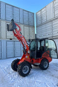 CanLift Mini Wheel Loader with Kubota D1703 engine, orange color – front view
Side view of CanLift compact loader with closed cabin and bucket raised
CanLift mini loader in operation – orange machine on construction site