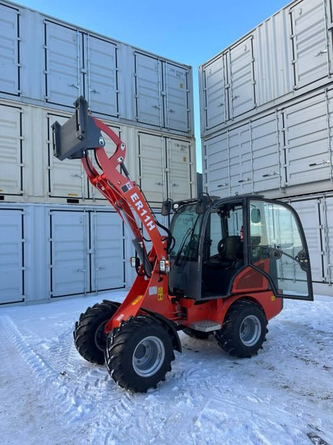 CanLift Mini Wheel Loader with Kubota D1703 engine, orange color – front view
Side view of CanLift compact loader with closed cabin and bucket raised
CanLift mini loader in operation – orange machine on construction site