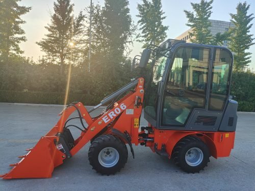 CanLift Mini Wheel Loader with Kubota D1703 engine
Orange and gray wheel loader with enclosed cabin
Compact loader with quick hitch and bucket
Mini loader for snow removal and landscaping
Hydrostatic drive mini loader with joystick control