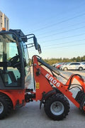 CanLift Mini Wheel Loader with Kubota D1703 engine
Orange and gray wheel loader with enclosed cabin
Compact loader with quick hitch and bucket
Mini loader for snow removal and landscaping
Hydrostatic drive mini loader with joystick control