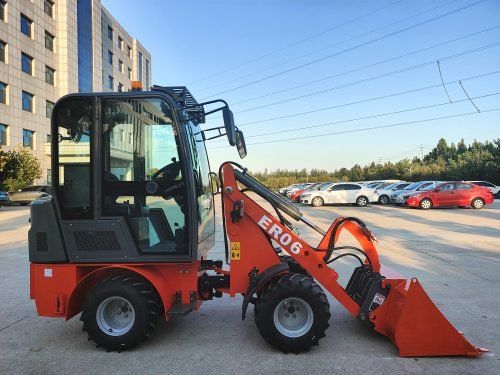 CanLift Mini Wheel Loader with Kubota D1703 engine
Orange and gray wheel loader with enclosed cabin
Compact loader with quick hitch and bucket
Mini loader for snow removal and landscaping
Hydrostatic drive mini loader with joystick control