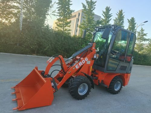 CanLift Mini Wheel Loader with Kubota D1703 engine
Orange and gray wheel loader with enclosed cabin
Compact loader with quick hitch and bucket
Mini loader for snow removal and landscaping
Hydrostatic drive mini loader with joystick control