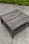 Dark gray oak square coffee table styled in a modern living room
Close-up of woodgrain texture and lower shelf
Angled view of the full table with storage items
The coffee table is placed with decorative accessories
Dark oak coffee table with books and a remote on the shelf