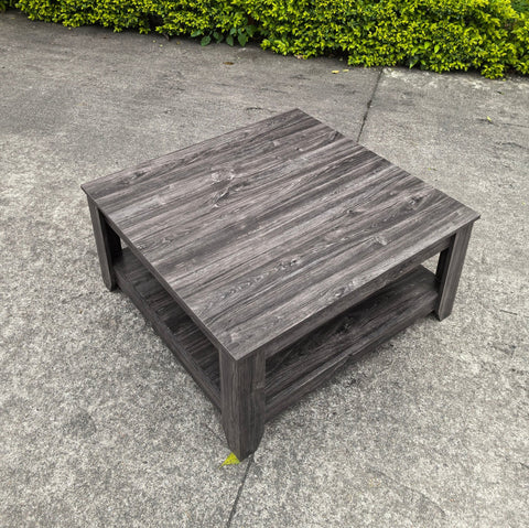 Dark gray oak square coffee table styled in a modern living room
Close-up of woodgrain texture and lower shelf
Angled view of the full table with storage items
The coffee table is placed with decorative accessories
Dark oak coffee table with books and a remote on the shelf