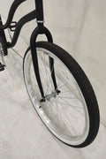 Side view of Deviant 26" beach cruiser bicycle in matte black

Close-up of comfort seat and handlebar grips

Rear coaster brake and single-speed drivetrain

Full assembled view of the Deviant black cruiser bike

Cruiser bike parked on a path at sunset