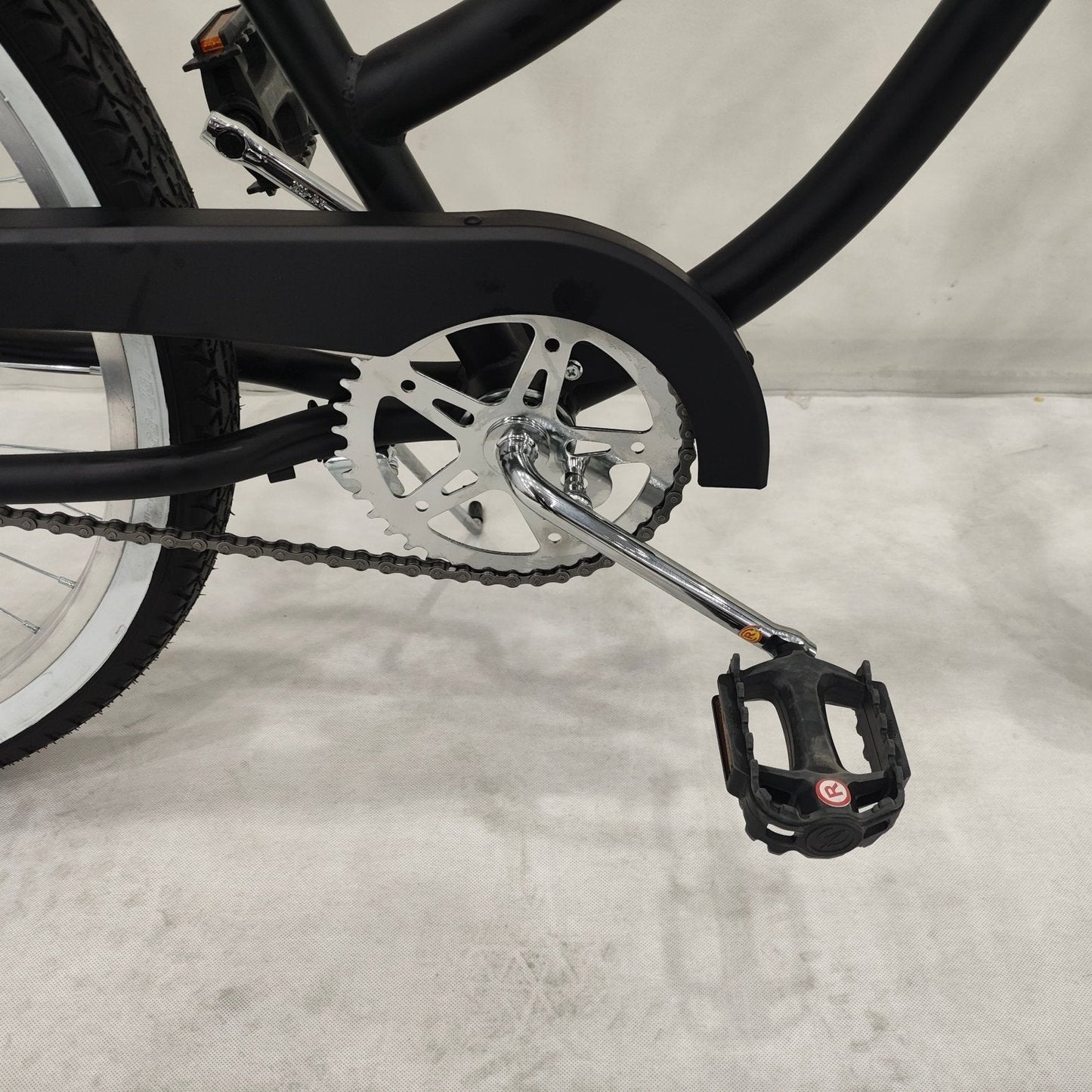 Side view of Deviant 26" beach cruiser bicycle in matte black

Close-up of comfort seat and handlebar grips

Rear coaster brake and single-speed drivetrain

Full assembled view of the Deviant black cruiser bike

Cruiser bike parked on a path at sunset