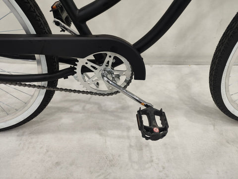 Side view of Deviant 26" beach cruiser bicycle in matte black

Close-up of comfort seat and handlebar grips

Rear coaster brake and single-speed drivetrain

Full assembled view of the Deviant black cruiser bike

Cruiser bike parked on a path at sunset