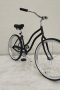Side view of Deviant 26" beach cruiser bicycle in matte black

Close-up of comfort seat and handlebar grips

Rear coaster brake and single-speed drivetrain

Full assembled view of the Deviant black cruiser bike

Cruiser bike parked on a path at sunset