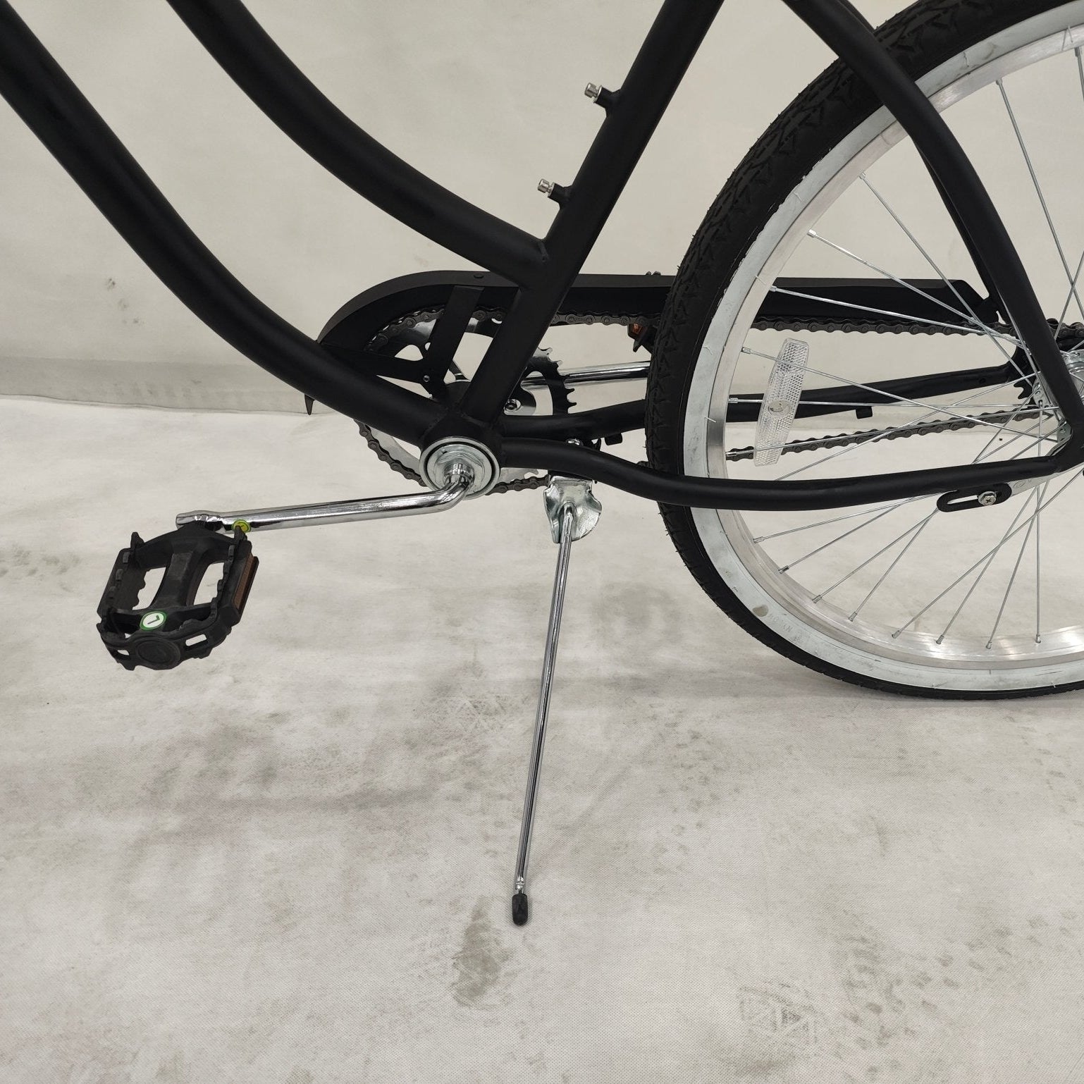 Side view of Deviant 26" beach cruiser bicycle in matte black

Close-up of comfort seat and handlebar grips

Rear coaster brake and single-speed drivetrain

Full assembled view of the Deviant black cruiser bike

Cruiser bike parked on a path at sunset