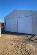 Double steel garage with roll-up doors, outdoor view

Interior view of metal garage barn frame

Roll-up electric overhead doors included in garage

Galvanized steel shed for vehicle and farm storage

Multiple-size all-weather garage options