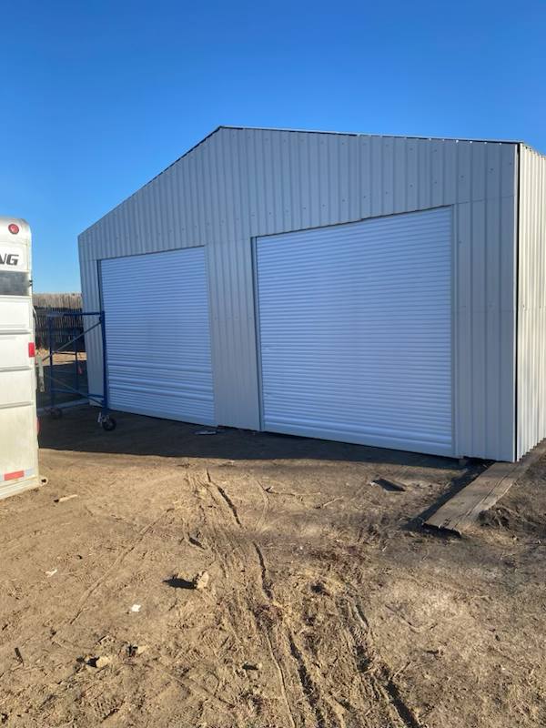 Double steel garage with roll-up doors, outdoor view

Interior view of metal garage barn frame

Roll-up electric overhead doors included in garage

Galvanized steel shed for vehicle and farm storage

Multiple-size all-weather garage options