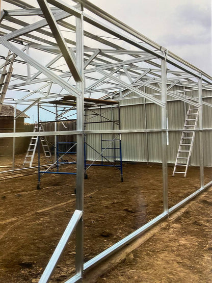 Double steel garage with roll-up doors, outdoor view

Interior view of metal garage barn frame

Roll-up electric overhead doors included in garage

Galvanized steel shed for vehicle and farm storage

Multiple-size all-weather garage options