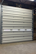 White insulated electric overhead garage door installed in shop
Heavy-duty motorized overhead garage door with steel frame
Electric garage door kit with insulation for industrial buildings
Overhead sectional garage door installed on warehouse