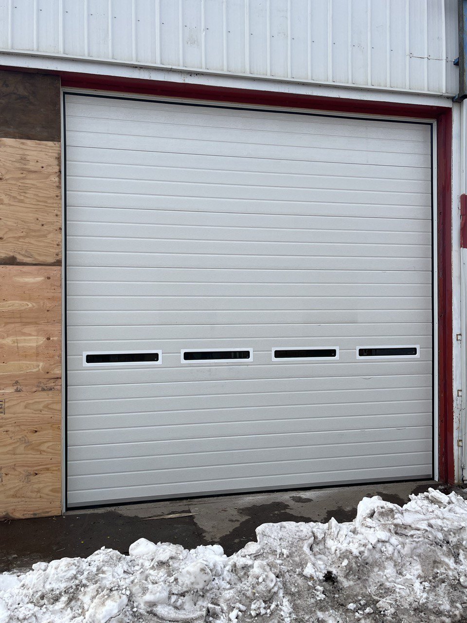 White insulated electric overhead garage door installed in shop
Heavy-duty motorized overhead garage door with steel frame
Electric garage door kit with insulation for industrial buildings
Overhead sectional garage door installed on warehouse