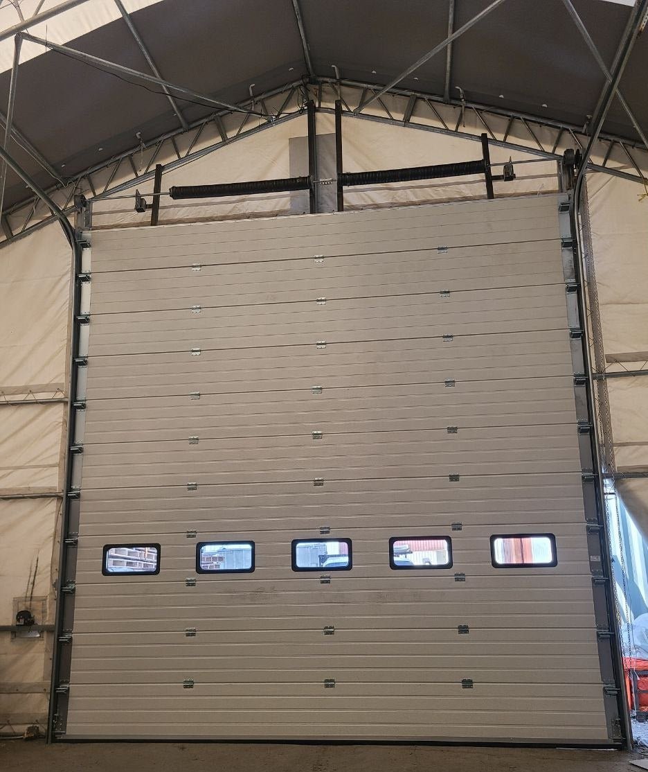 White insulated electric overhead garage door installed in shop
Heavy-duty motorized overhead garage door with steel frame
Electric garage door kit with insulation for industrial buildings
Overhead sectional garage door installed on warehouse