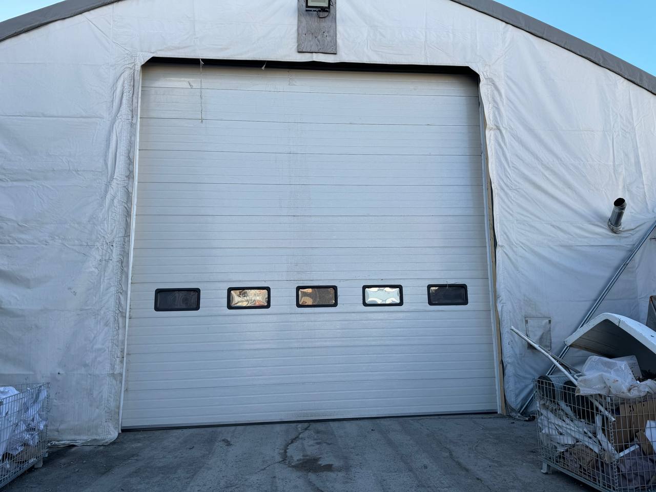 White insulated electric overhead garage door installed in shop
Heavy-duty motorized overhead garage door with steel frame
Electric garage door kit with insulation for industrial buildings
Overhead sectional garage door installed on warehouse