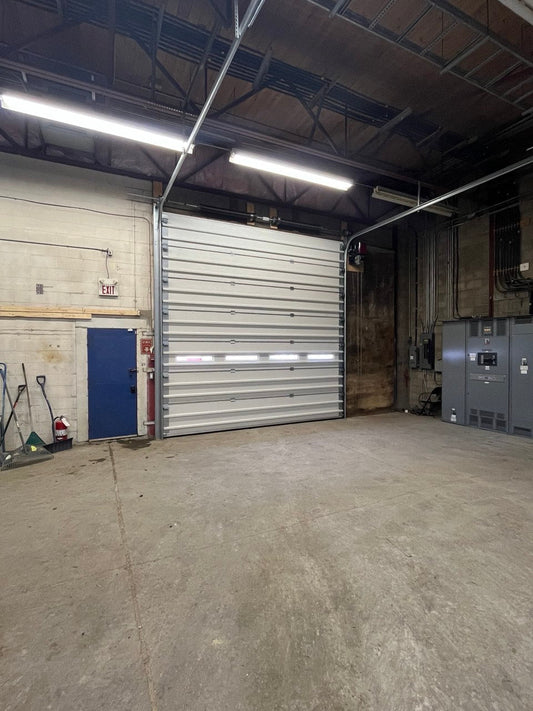 White insulated electric overhead garage door installed in shop
Heavy-duty motorized overhead garage door with steel frame
Electric garage door kit with insulation for industrial buildings
Overhead sectional garage door installed on warehouse