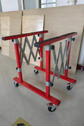 Red expanding folding table with padded surface for windshield and body panel work

