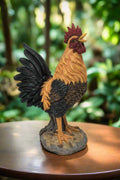 Front view of hand-painted crowing rooster garden statue on patio