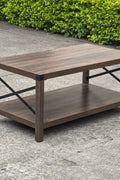 Gray wash rustic coffee table with metal X-frame in the living room
Front view of the coffee table showing shelf storage
Side angle showing gray tabletop and open shelf
Coffee table outdoors with accessories
Detail of gray wash wood and black frame