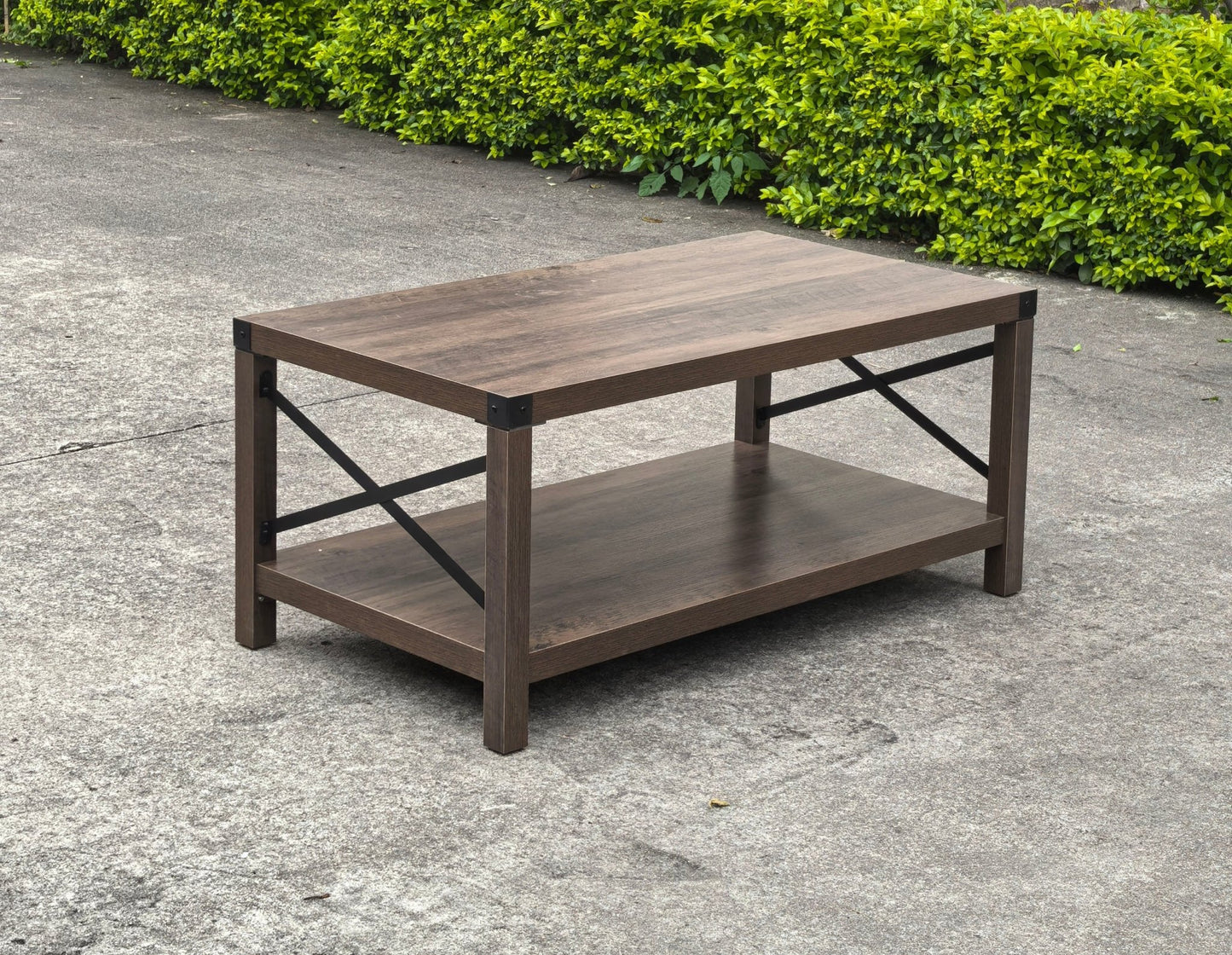Gray wash rustic coffee table with metal X-frame in the living room
Front view of the coffee table showing shelf storage
Side angle showing gray tabletop and open shelf
Coffee table outdoors with accessories
Detail of gray wash wood and black frame