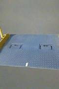 Heavy-duty steel loading dock ramp on warehouse floor

Industrial dock ramp with yellow safety rails

Forklift-ready steel dock board in use

Side view of 15,000 lb steel dock ramp

Loading dock ramp with chain attachment system