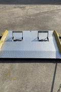 Heavy-duty steel loading dock ramp on warehouse floor

Industrial dock ramp with yellow safety rails

Forklift-ready steel dock board in use

Side view of 15,000 lb steel dock ramp

Loading dock ramp with chain attachment system