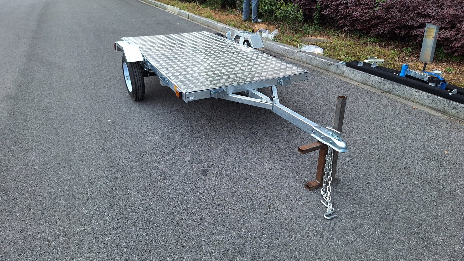 Heavy-duty galvanized 4x8 folding utility trailer with checker plate deck and road-ready tires