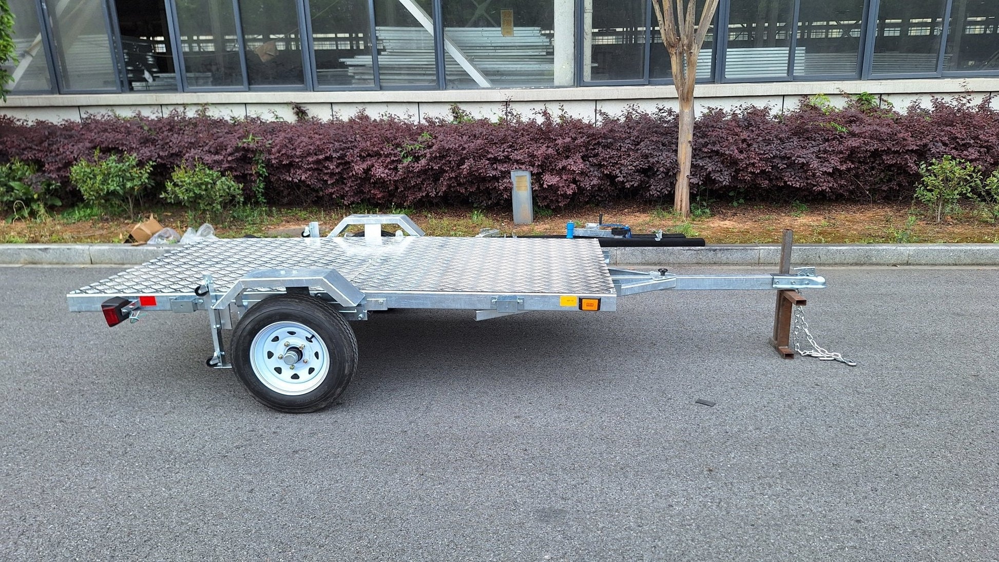 Heavy-duty galvanized 4x8 folding utility trailer with checker plate deck and road-ready tires