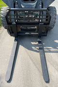 Heavy-duty skid steer pallet forks lifting a load

CNC carriage bar with quick attach mounting

Close-up of forks locked in carriage slots

Side step feature on fork frame

Variants of 48", 60", 72", and 96" forks shown on pallet