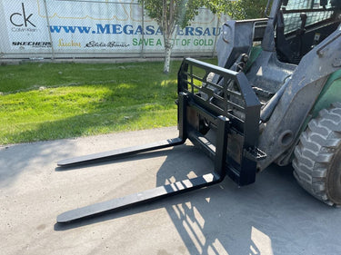 Heavy-duty skid steer pallet forks lifting a load

CNC carriage bar with quick attach mounting

Close-up of forks locked in carriage slots

Side step feature on fork frame

Variants of 48