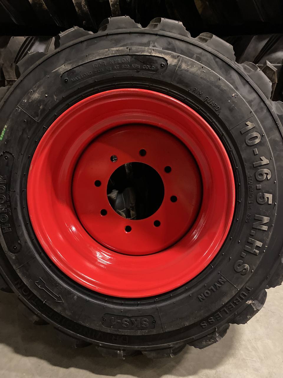 “Heavy duty skid steer tires with aggressive tread”

“SKS-1 and SKS-4 tires for Bobcat A300 and S750”

“Skid steer tires with red and silver rims”

“10x16.5 to 15x19.5 skid steer tire variants”

“Close-up of durable construction skid steer tire”

