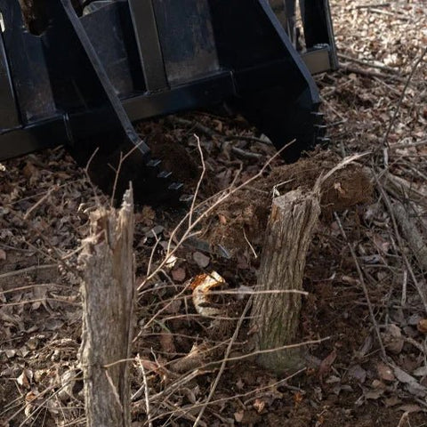 Tree Grubber Attachment front view mounted on skid steer
Close-up of cutting edge removing root
Attachment digging under tree taproot
Brush and root removal tool in action