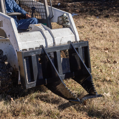 Tree Grubber Attachment front view mounted on skid steer
Close-up of cutting edge removing root
Attachment digging under tree taproot
Brush and root removal tool in action