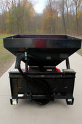 Skid Steer Tilt-N-Scoop Material Spreader front view
Side profile of spreader mounted on skid steer
Hydraulic spreader with sidewalk shield
Top view of hopper and agitator
Spreader attachment in action with sand