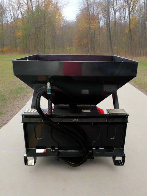 Skid Steer Tilt-N-Scoop Material Spreader front view
Side profile of spreader mounted on skid steer
Hydraulic spreader with sidewalk shield
Top view of hopper and agitator
Spreader attachment in action with sand