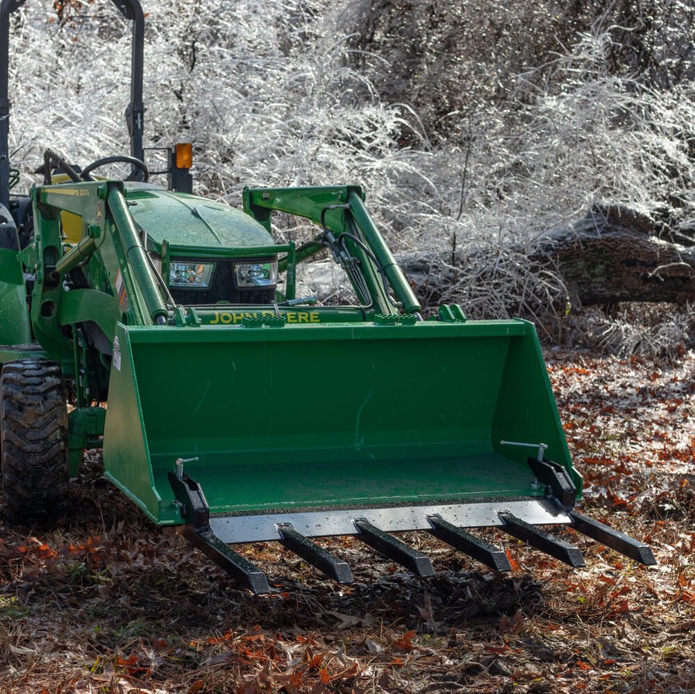 Clamp-on debris fork attachment on black tractor bucket – 60 inch
Green John Deere tractor with clamp-on fork attachment hauling debris
72-inch clamp-on debris forks mounted on front loader
