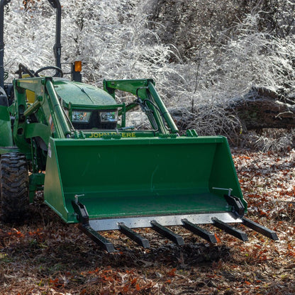 Clamp-on debris fork attachment on black tractor bucket – 60 inch
Green John Deere tractor with clamp-on fork attachment hauling debris
72-inch clamp-on debris forks mounted on front loader