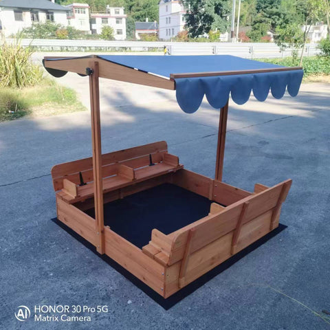 Wooden sandbox with canopy fully extended and benches visible

Close-up of sandbox lid cover in closed position

Children playing inside wooden sandbox with canopy

Side angle showing bench detail and canopy fabric

Folded sandbox closed with protective cover on top