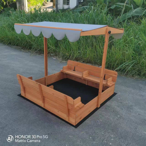 Wooden sandbox with canopy fully extended and benches visible

Close-up of sandbox lid cover in closed position

Children playing inside wooden sandbox with canopy

Side angle showing bench detail and canopy fabric

Folded sandbox closed with protective cover on top