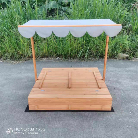 Wooden sandbox with canopy fully extended and benches visible

Close-up of sandbox lid cover in closed position

Children playing inside wooden sandbox with canopy

Side angle showing bench detail and canopy fabric

Folded sandbox closed with protective cover on top
