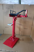 Manual tire changer and spreader stand with red base and swivel platform
Tire changer stand showing adjustable tilt function and tool tray
Manual tire repair stand for light truck tires in auto repair garage