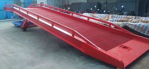 Red 22,000 lb dock ramp showing tread surface and guard rails