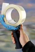 Mouse trap style tape gun in hand during use

Tape gun dispenser with ergonomic grip and metal body

Close-up of T250426 heavy-duty tape gun loading area

Heavy-duty black and blue packing tape dispenser

Shipping tape dispenser shown with standard tape roll

