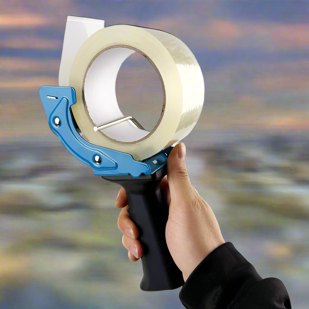 Mouse trap style tape gun in hand during use

Tape gun dispenser with ergonomic grip and metal body

Close-up of T250426 heavy-duty tape gun loading area

Heavy-duty black and blue packing tape dispenser

Shipping tape dispenser shown with standard tape roll

