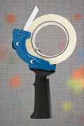 Mouse trap style tape gun in hand during use

Tape gun dispenser with ergonomic grip and metal body

Close-up of T250426 heavy-duty tape gun loading area

Heavy-duty black and blue packing tape dispenser

Shipping tape dispenser shown with standard tape roll

