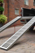 ATV and lawn mower ramp set mounted on vehicle trailer bed

