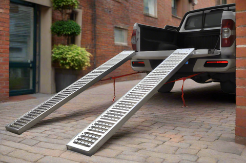 ATV and lawn mower ramp set mounted on vehicle trailer bed

